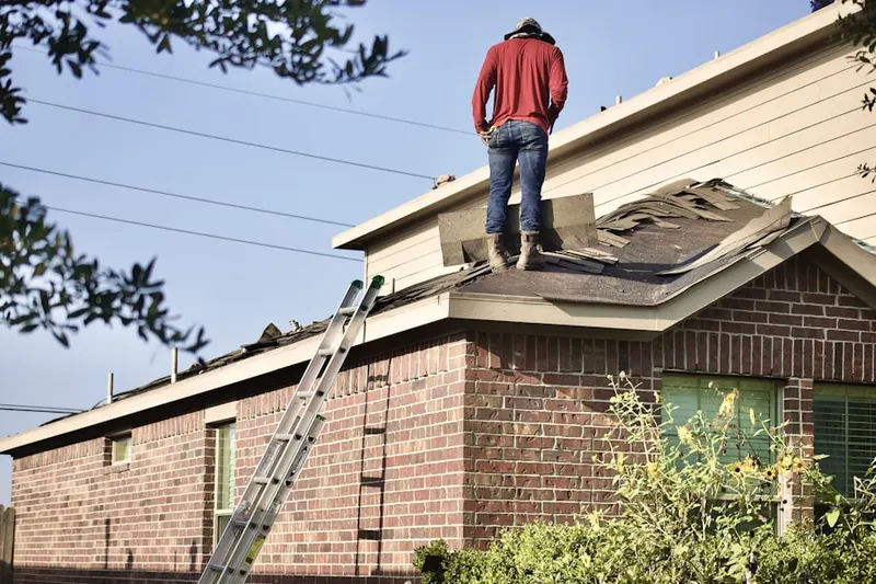 Professional roofer working on a residential roof in Alsace Manor